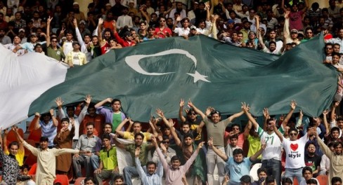 Pakistani cricket fans cheer during the Pakistan and India ICC Cricket World Cup semi-final match on a large screen inside the grounds of a stadium in Lahore